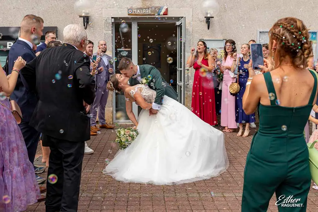 Le marié enlace la mariée à la sortie de la mairie