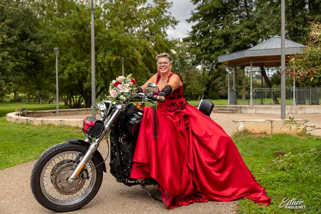 Mariée en rouge assise sur une moto